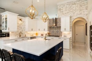 Modern kitchen featuring a quartz countertop, white cabinetry, and decorative tile backsplash, showcasing a blend of functionality and style.