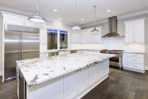 Contemporary kitchen featuring a large quartz worktop, stainless steel appliances, and white cabinetry, ideal for modern home designs.