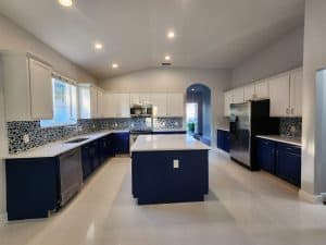Spacious modern kitchen featuring blue cabinets, quartz countertops, and stainless steel appliances, ideal for contemporary home designs.