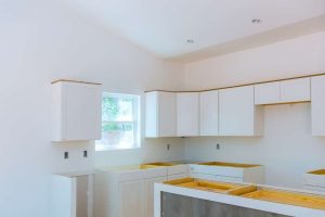 Unfinished kitchen featuring white cabinets and countertop space, showcasing a modern design ideal for quartz surfaces.