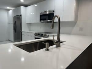 Contemporary kitchen worktop featuring a stainless steel sink and sleek faucet, ideal for modern kitchen designs and renovations.